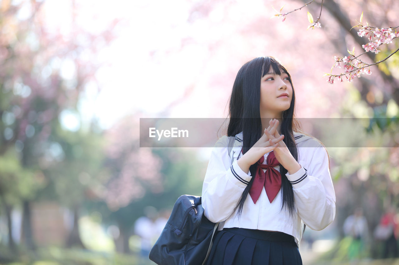 Portrait of beautiful young woman standing outdoors