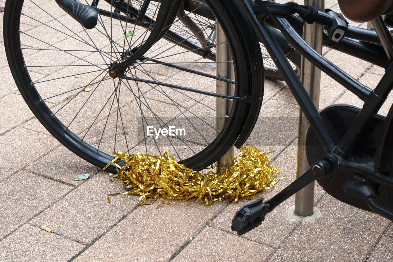 Black bicycle in city adorned with golden garland
