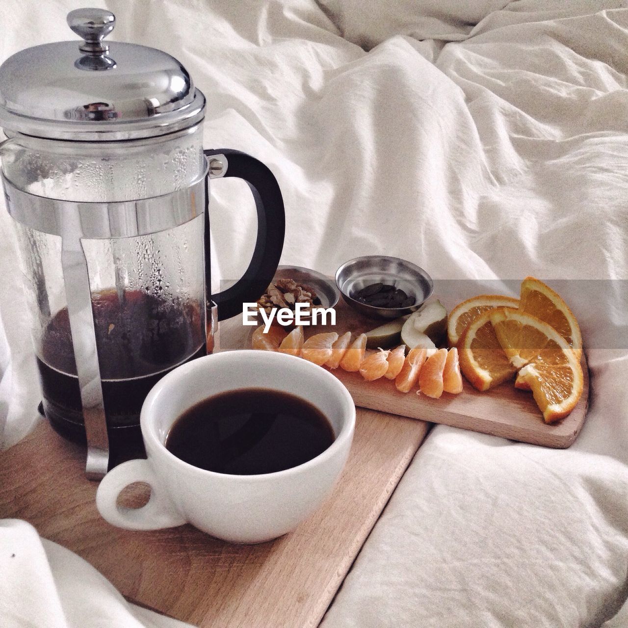High angle view of black coffee and fruit served on bed