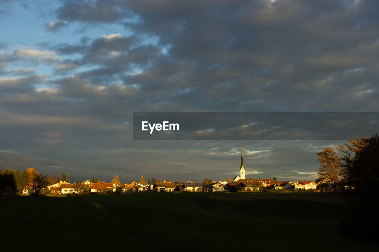 View of illuminated city against cloudy sky