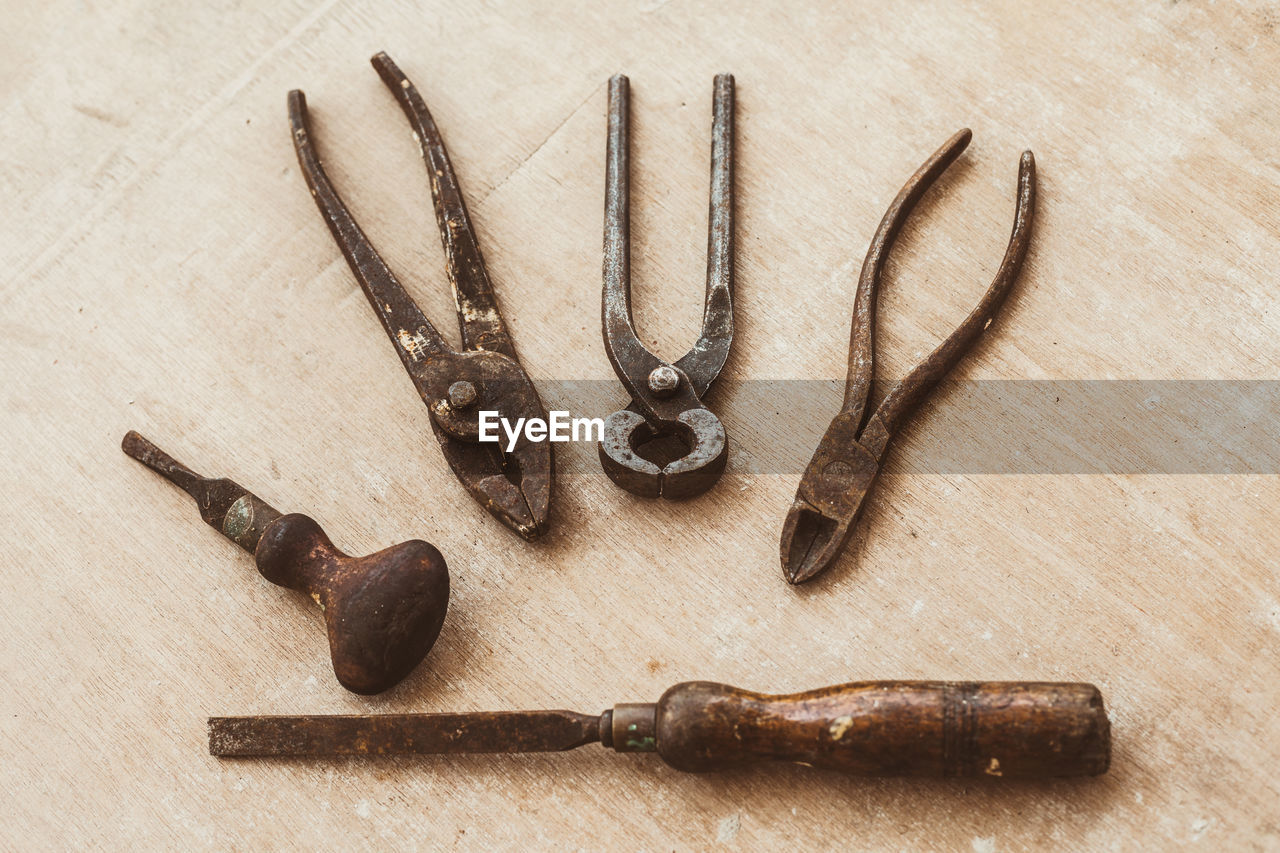 High angle view of rusty work tool on table