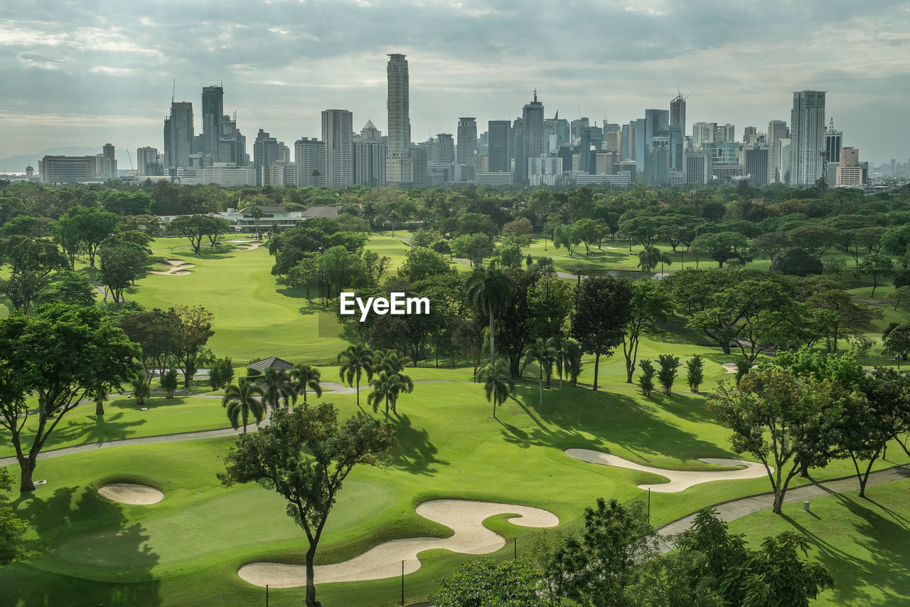 Panoramic view of trees and cityscape against sky