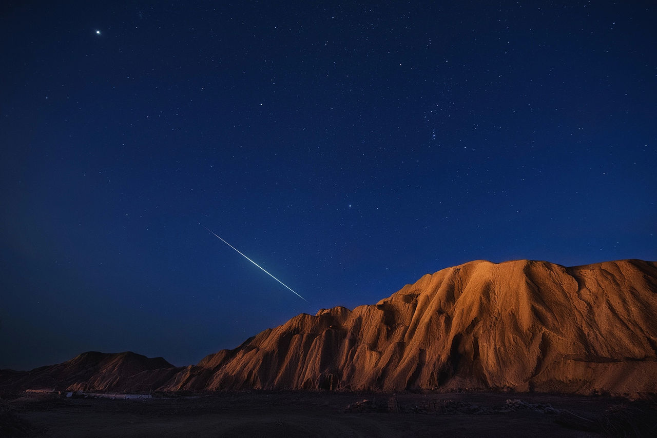 Scenic view of mountain against sky at night