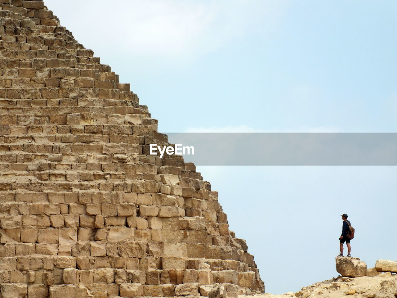 Man standing by historical building against sky