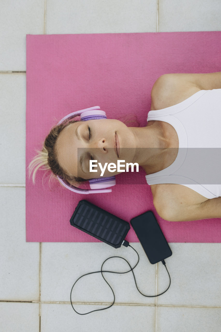 Woman with closed eyes listening to music with headphones and relaxing