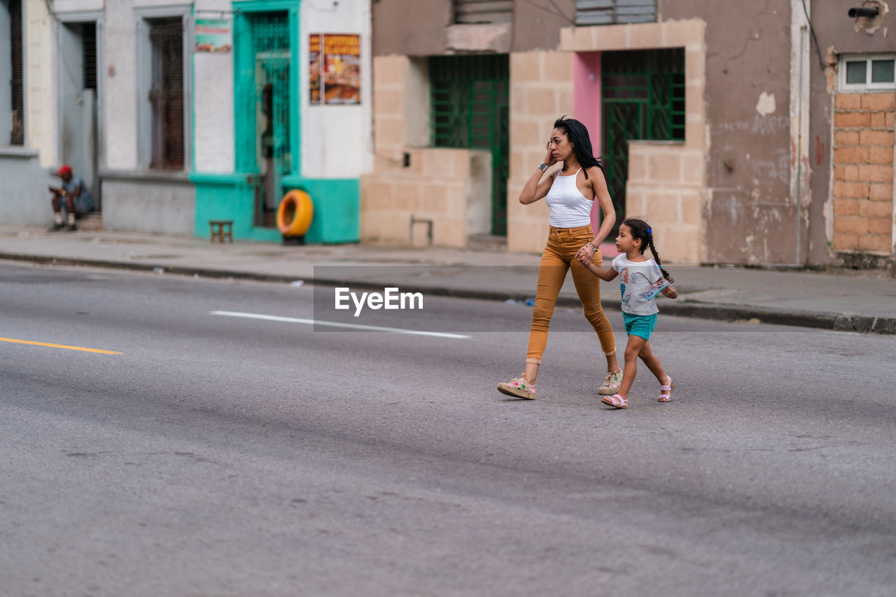 FULL LENGTH OF MOTHER AND DAUGHTER ON ROAD