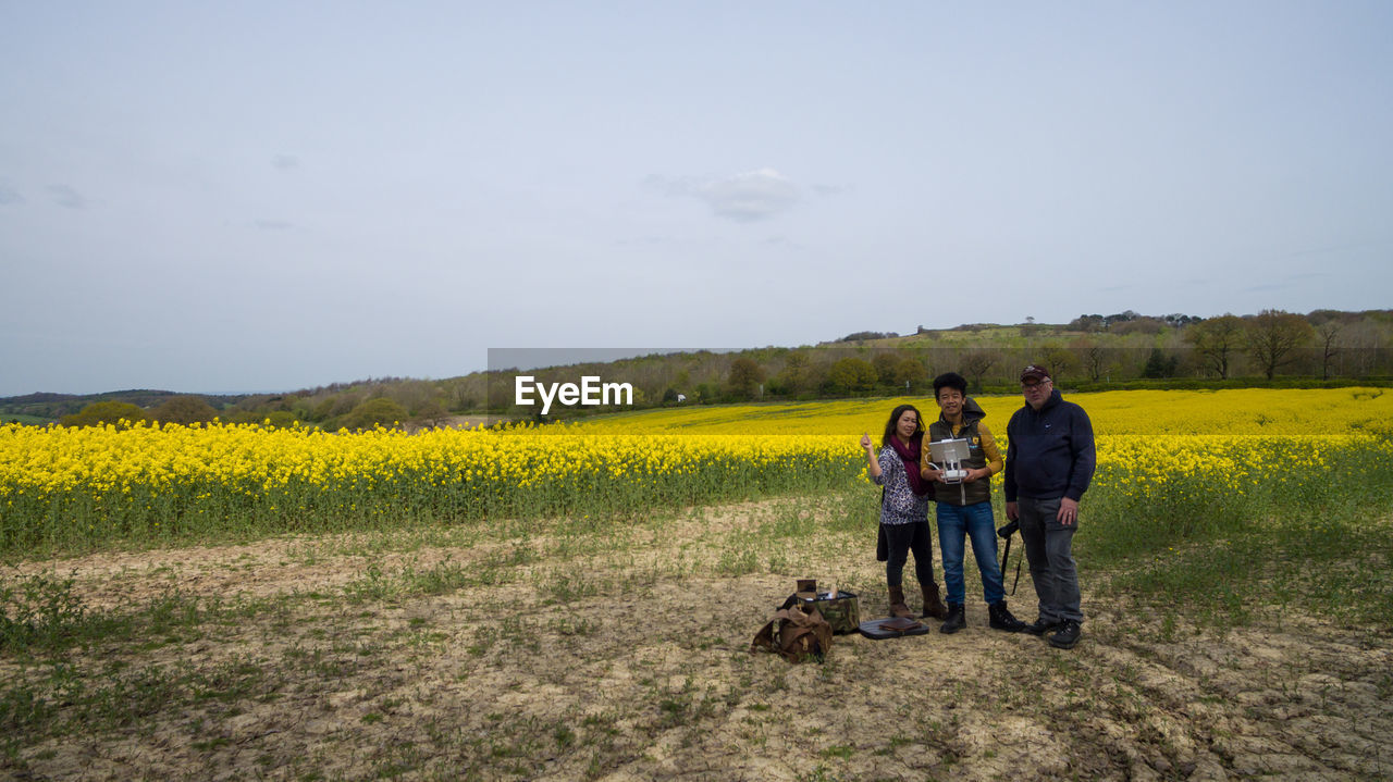 REAR VIEW OF WOMEN WALKING ON FIELD