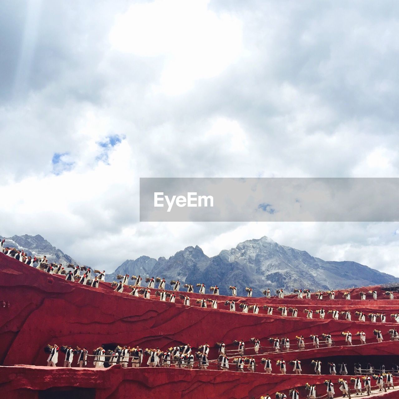 Artists performing at jade dragon snow mountain against sky