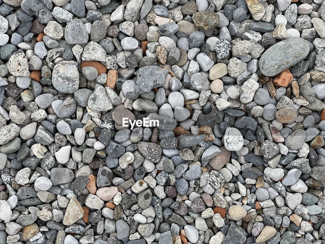 HIGH ANGLE VIEW OF STONES ON PEBBLES