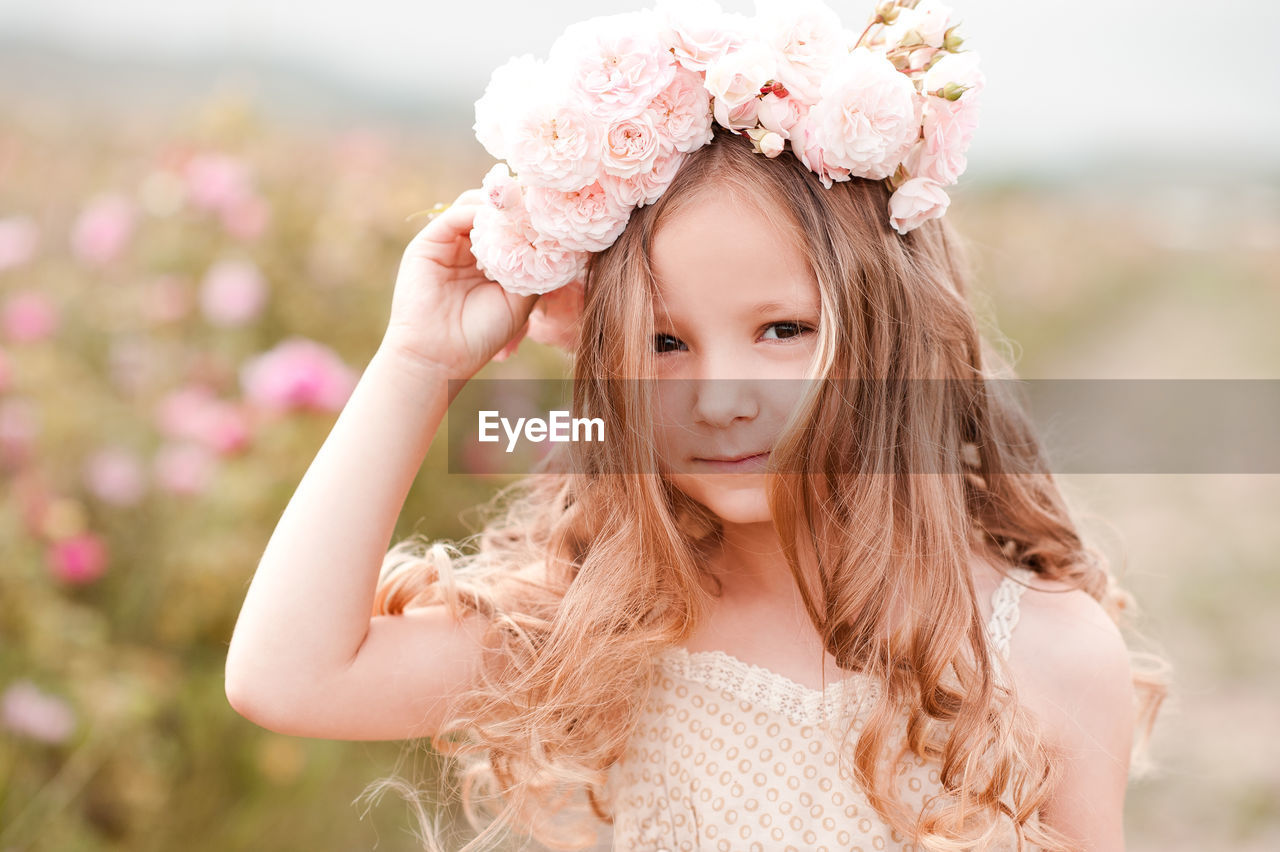 Portrait of cute girl wearing wreath at farm