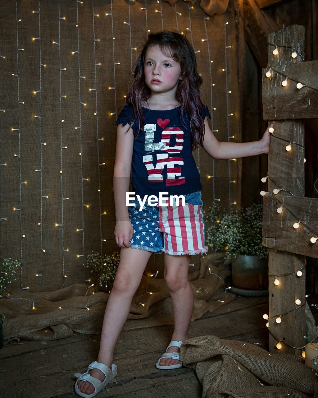 FULL LENGTH PORTRAIT OF GIRL STANDING AGAINST ILLUMINATED BUILDING