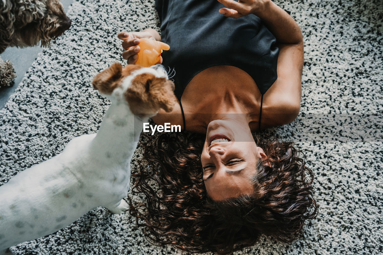 High angle view of woman and dogs on floor