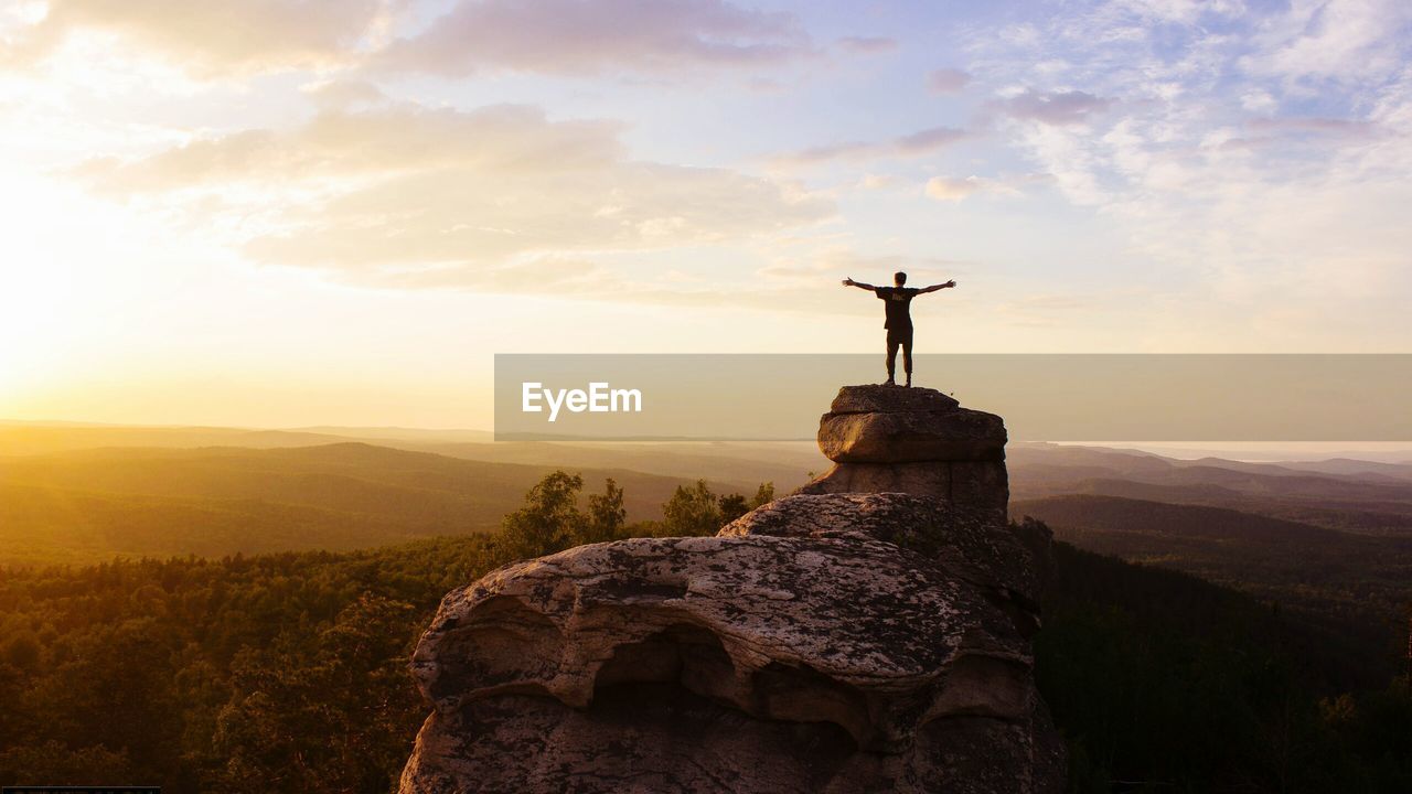 Silhouette of person standing on rock