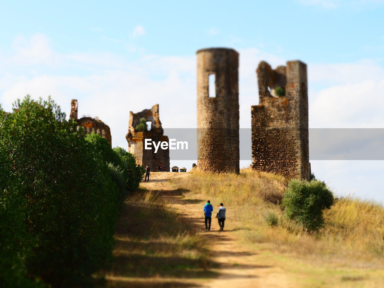 PEOPLE WALKING ON OLD CASTLE AGAINST BUILDINGS