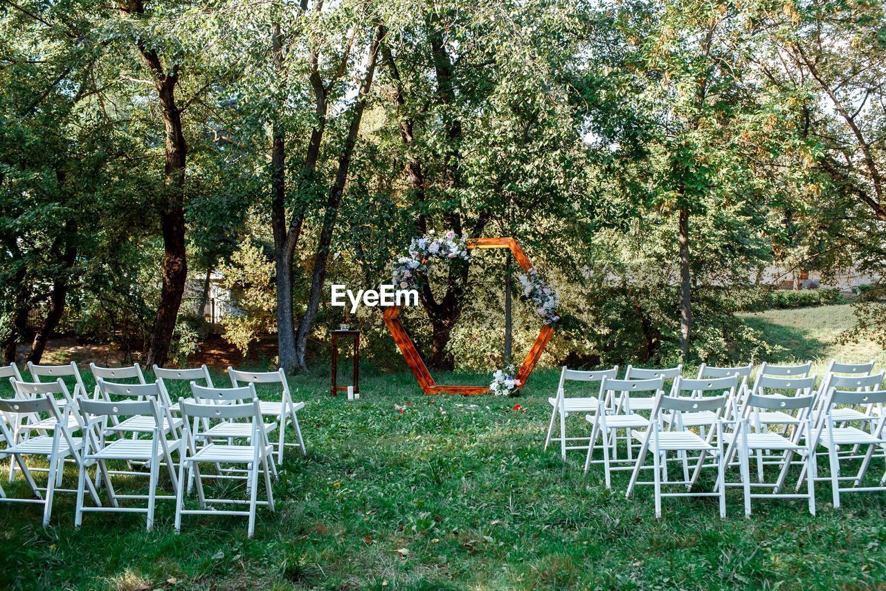 EMPTY CHAIRS AND TABLE IN PARK DURING AUTUMN