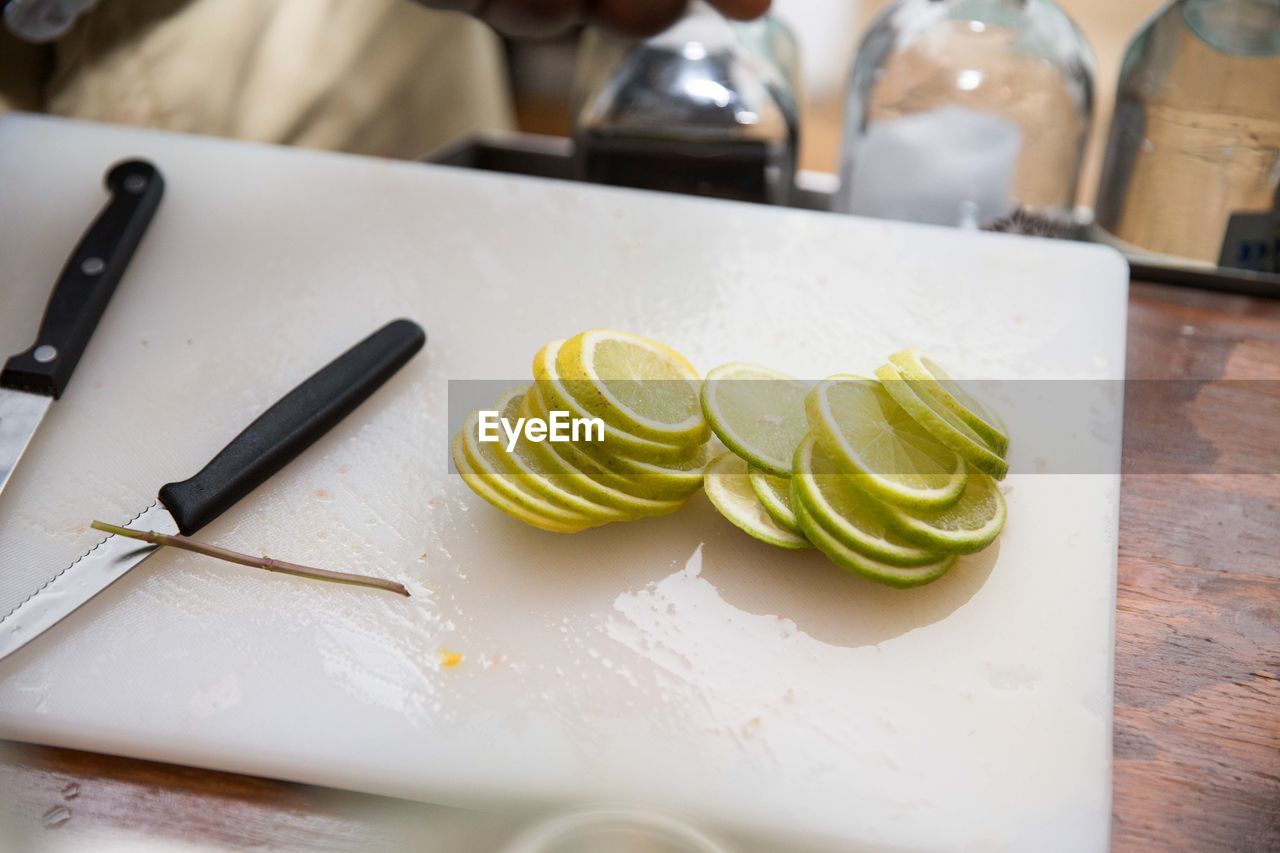 Lemon slice with knife on cutting board