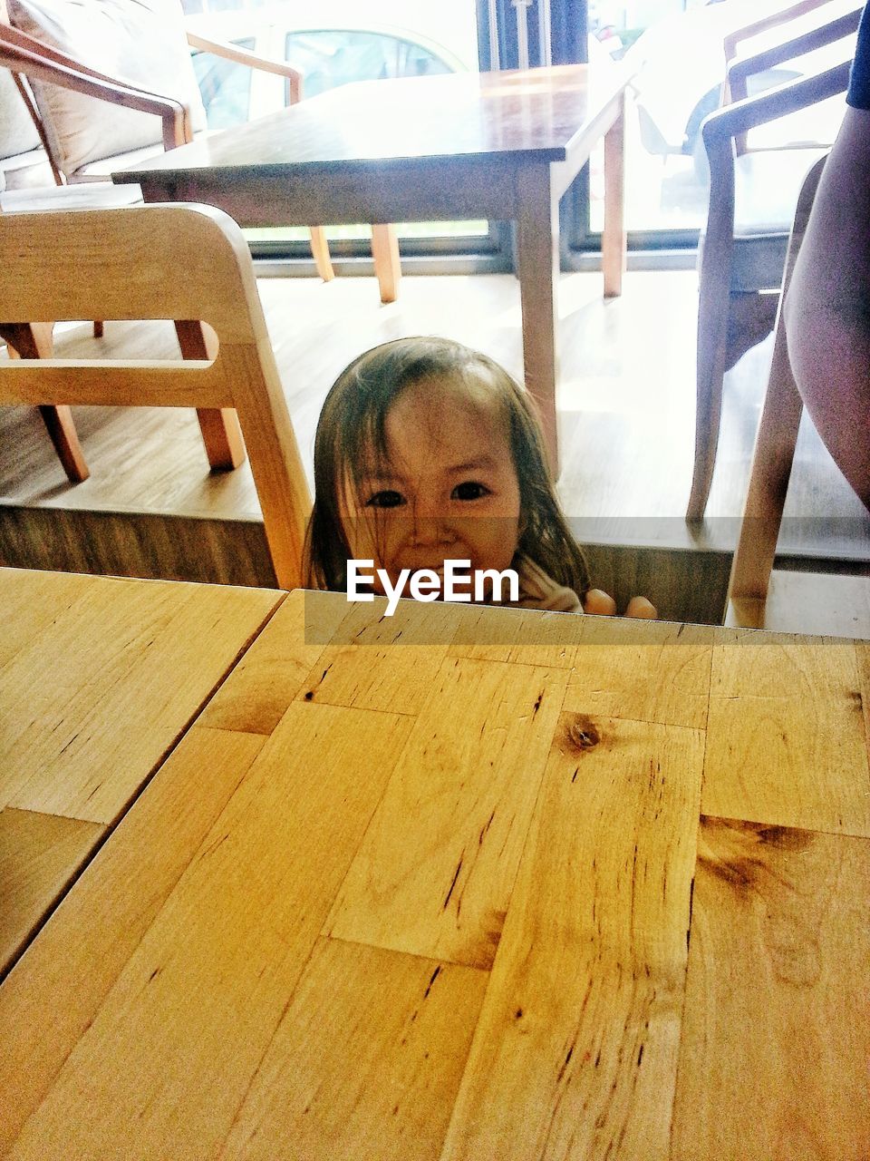 PORTRAIT OF CUTE GIRL SITTING ON TABLE