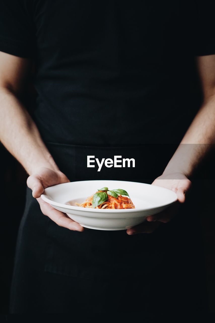 Midsection of man holding ice cream in plate