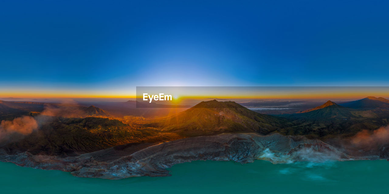 SCENIC VIEW OF LAKE AND MOUNTAINS AGAINST SKY DURING SUNSET