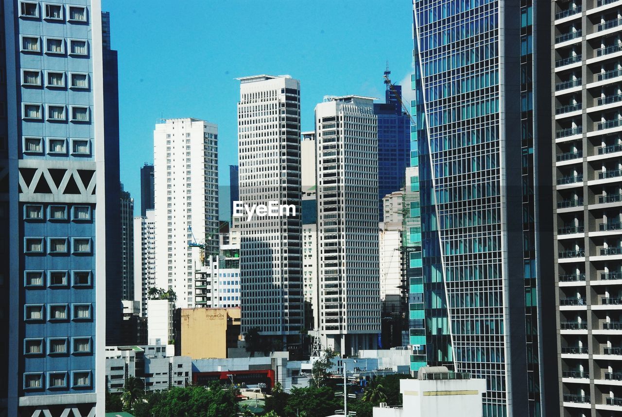 Buildings in city against blue sky