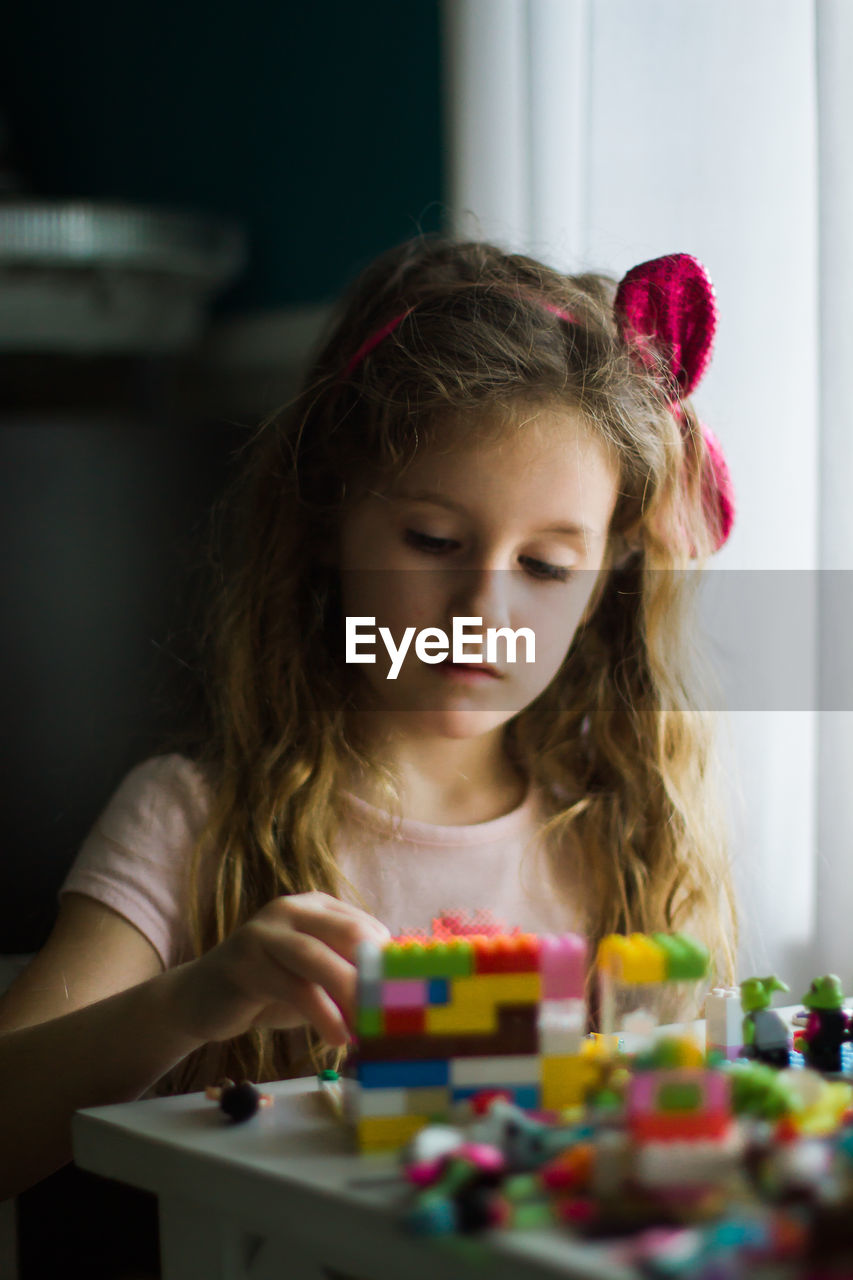 Girl playing with multicolored blocks