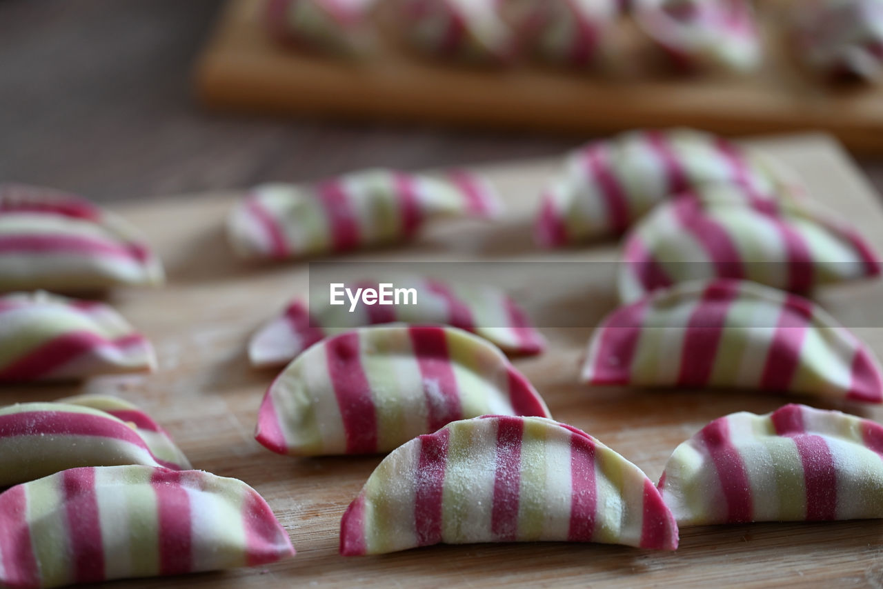 food and drink, food, dessert, pink, baked, indoors, no people, freshness, icing, snack, sweetness, close-up, cutting board, produce, dish towel, striped, wood, dish, selective focus, still life, in a row, vegetable, studio shot, focus on foreground, healthy eating