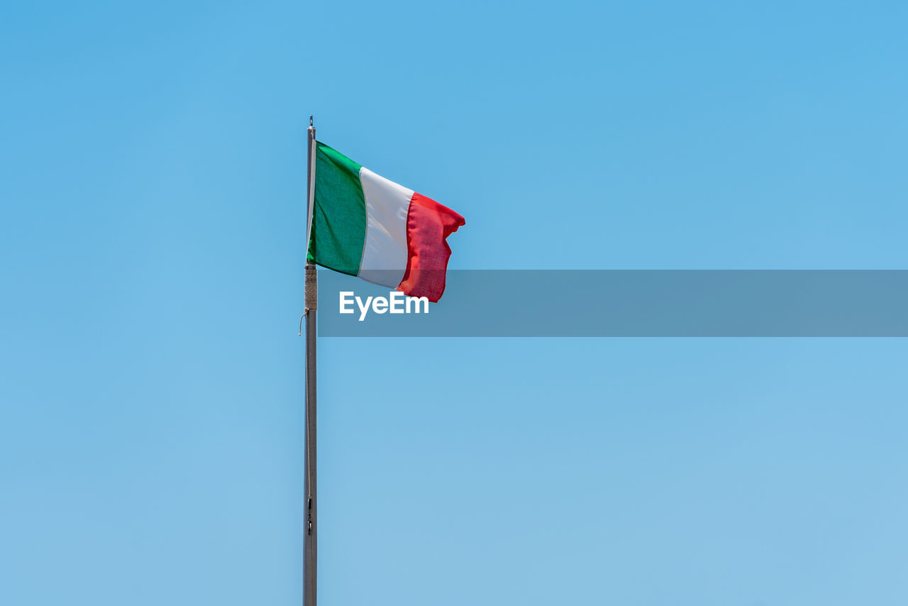 LOW ANGLE VIEW OF FLAG AGAINST BLUE SKY