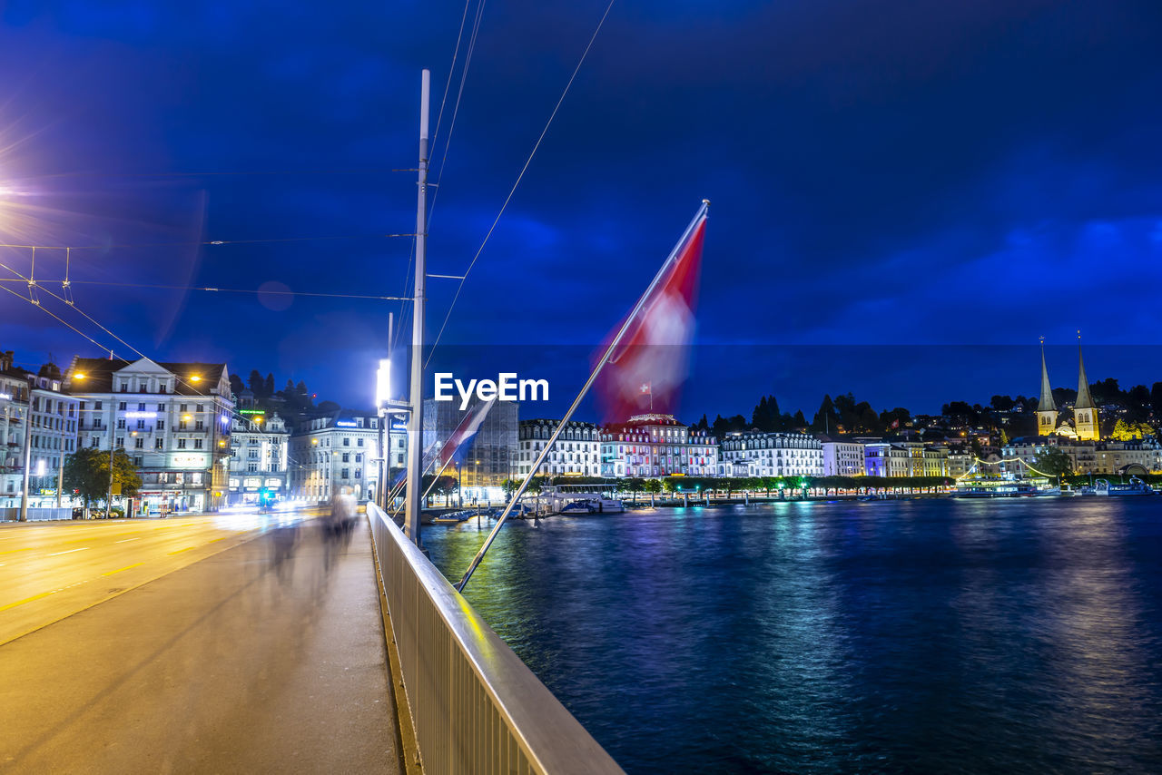 Bridge over reuss river with cityscape at night in lucerne, switzerland.