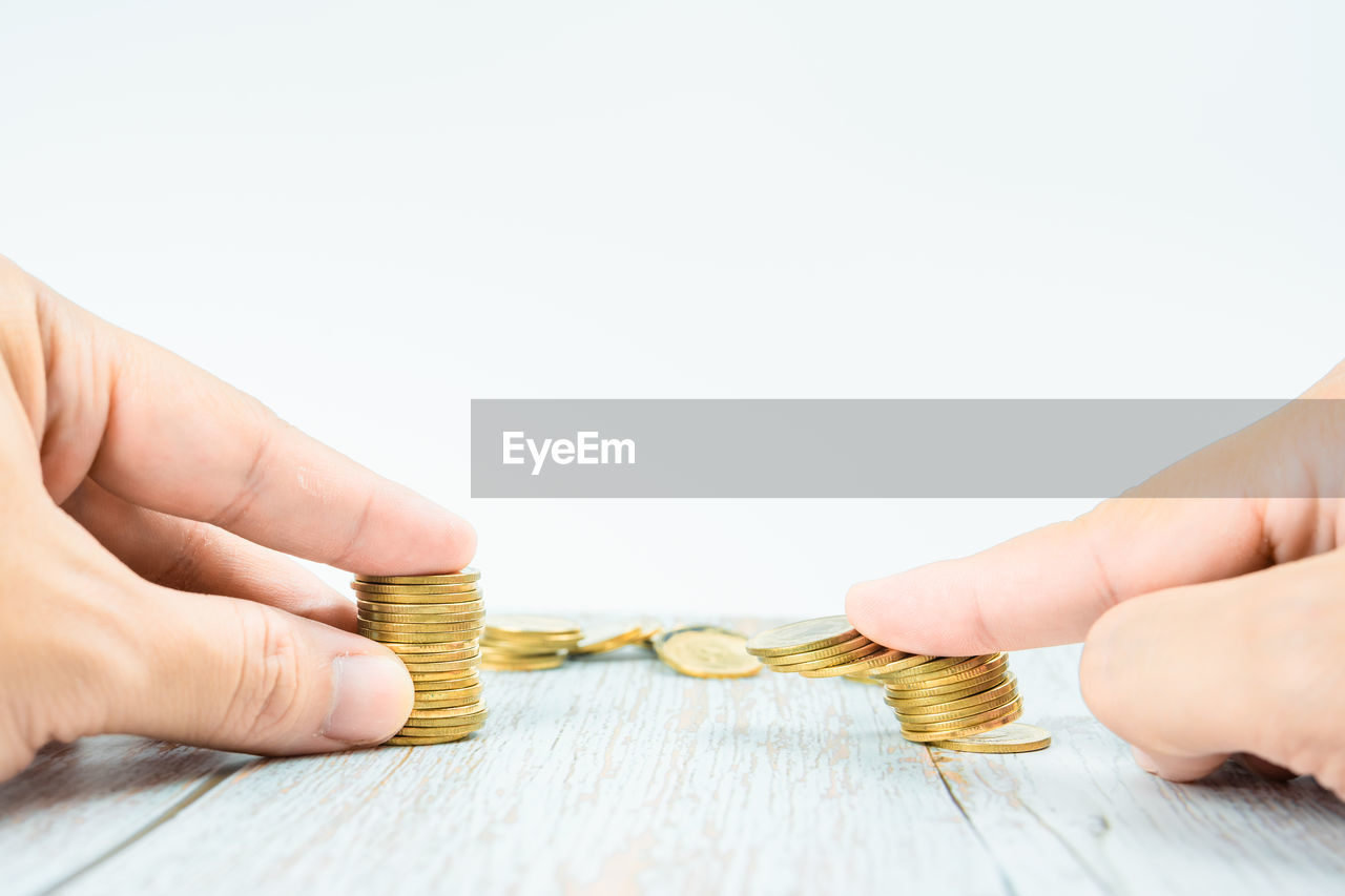 hand, finance, business, savings, currency, adult, indoors, studio shot, wood, wealth, close-up, holding, copy space, finger, one person, coin, business finance and industry, investment, success, women