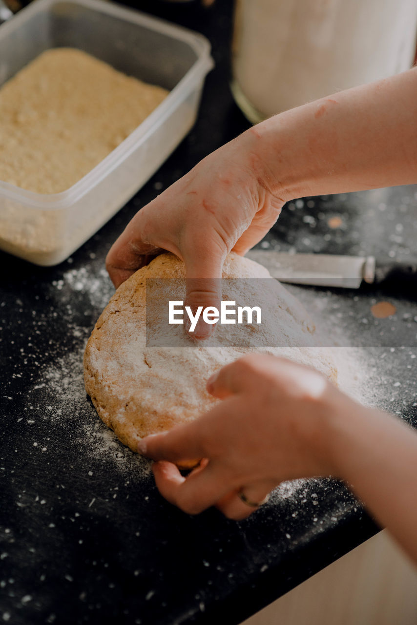 CLOSE-UP OF HAND HOLDING BURGER