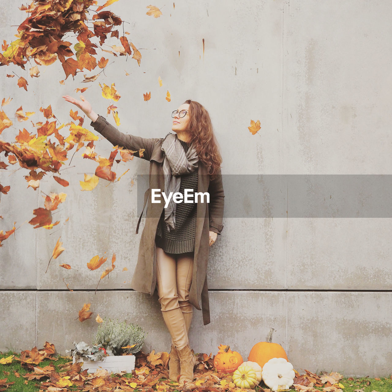 Full length of woman standing on wall during autumn