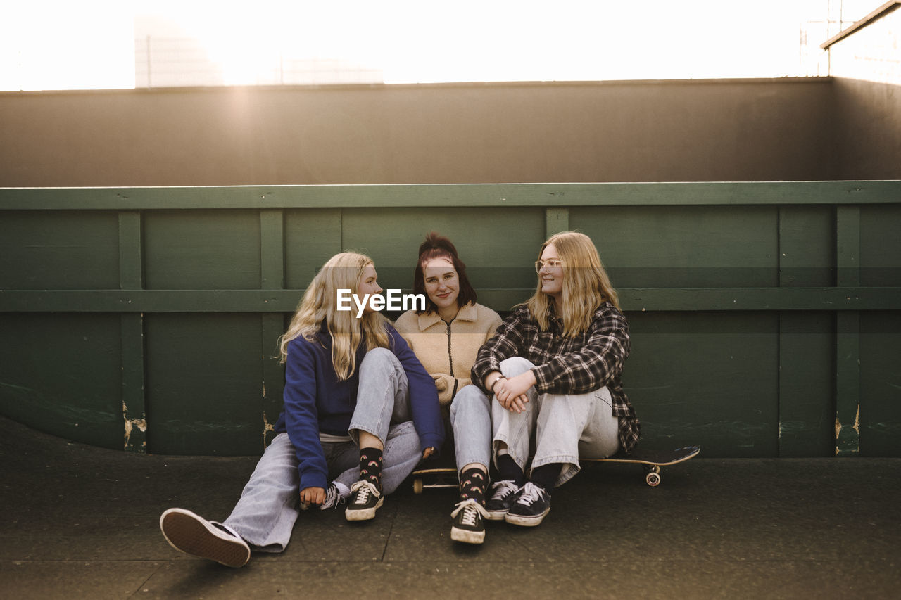 Smiling teenage girls with skateboards