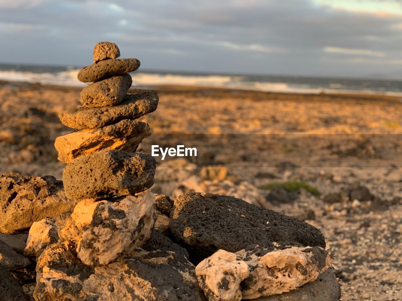 CLOSE-UP OF STACK OF STONES ON BEACH