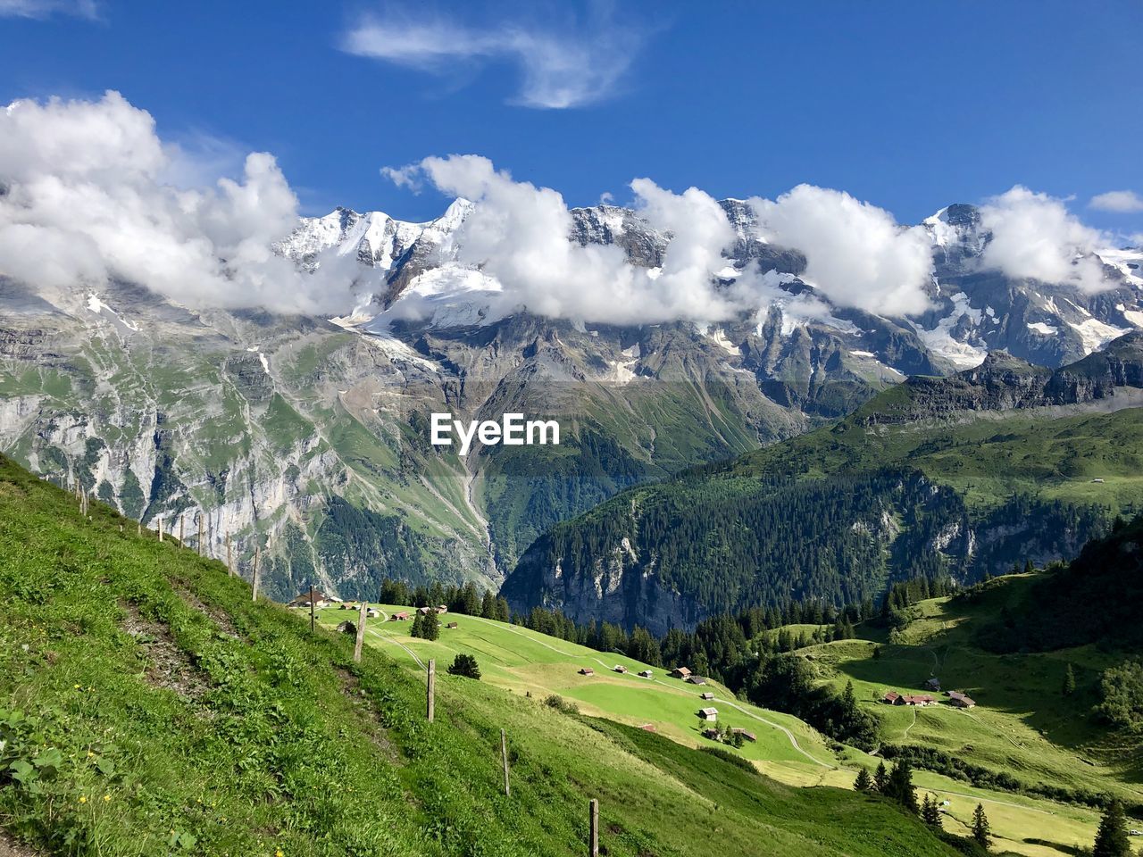 Panoramic view of green landscape and mountains against sky