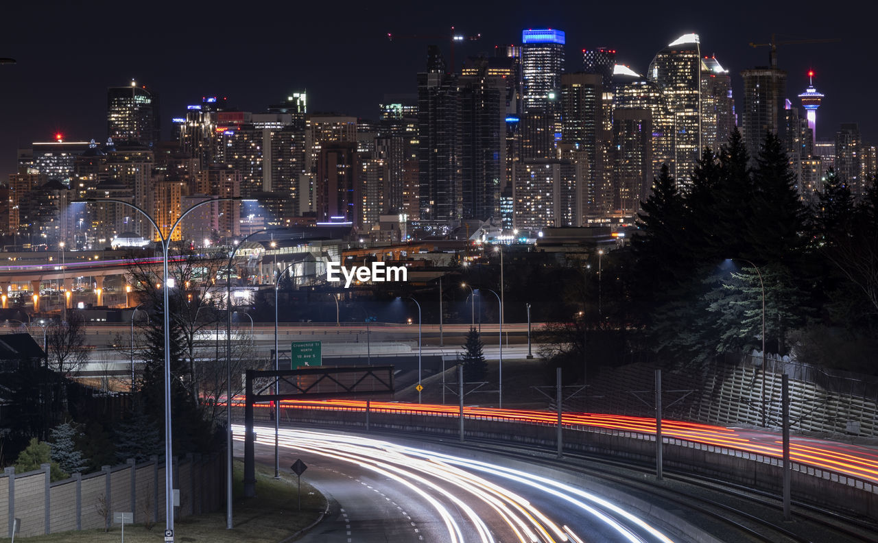 High angle view of car light tails against cityscape at night