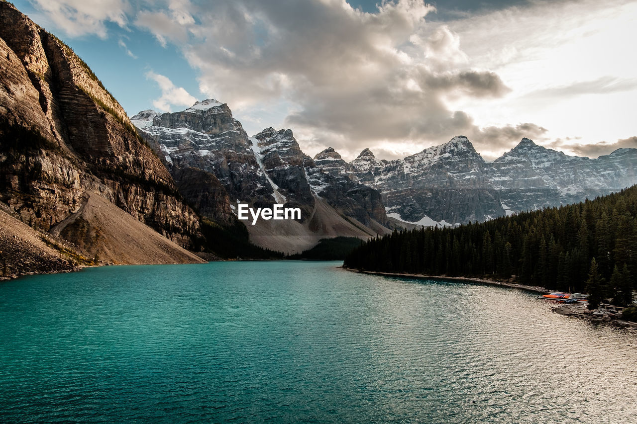 Scenic view of lake by mountains against sky