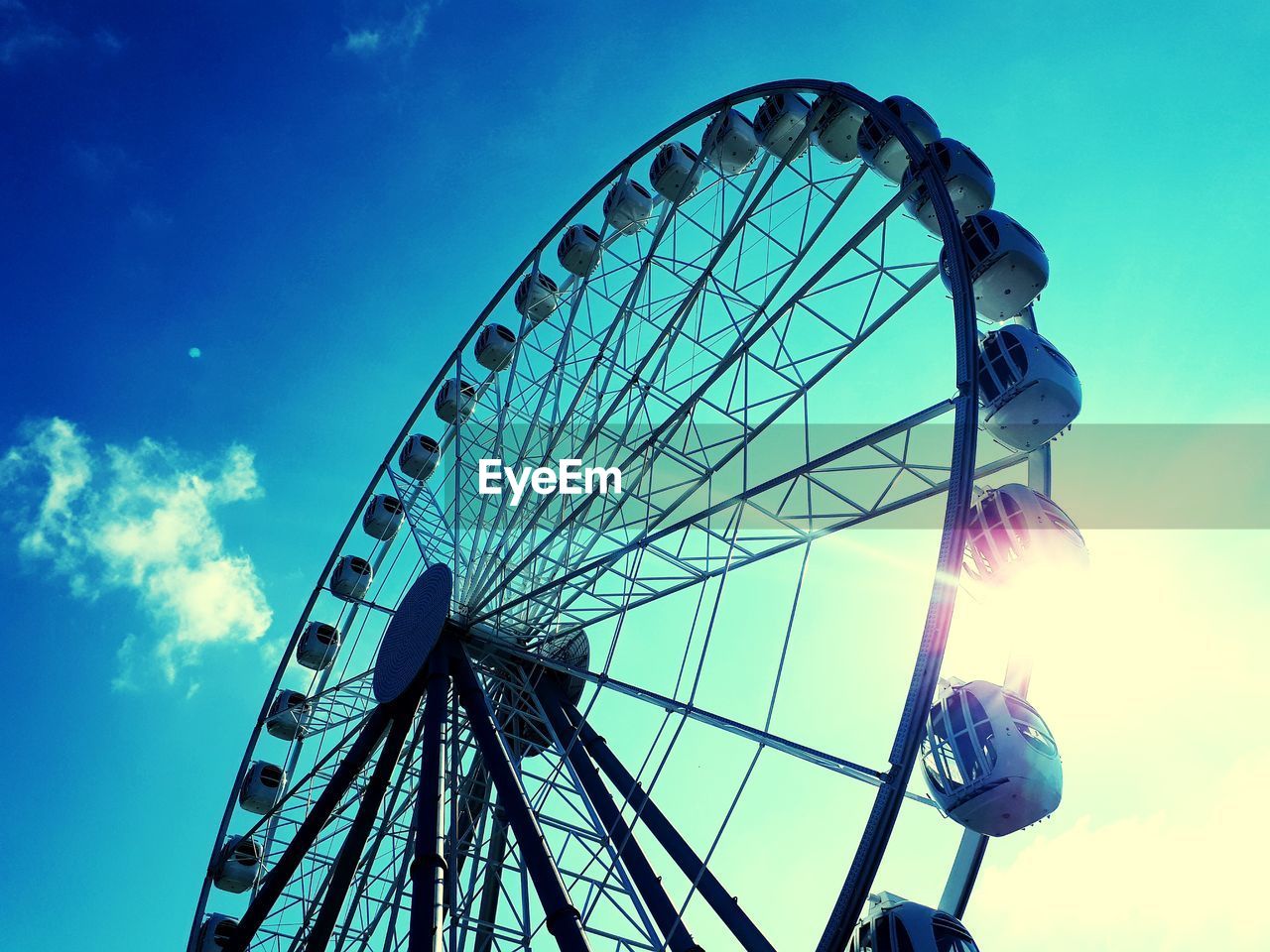 LOW ANGLE VIEW OF FERRIS WHEEL AGAINST CLOUDY SKY