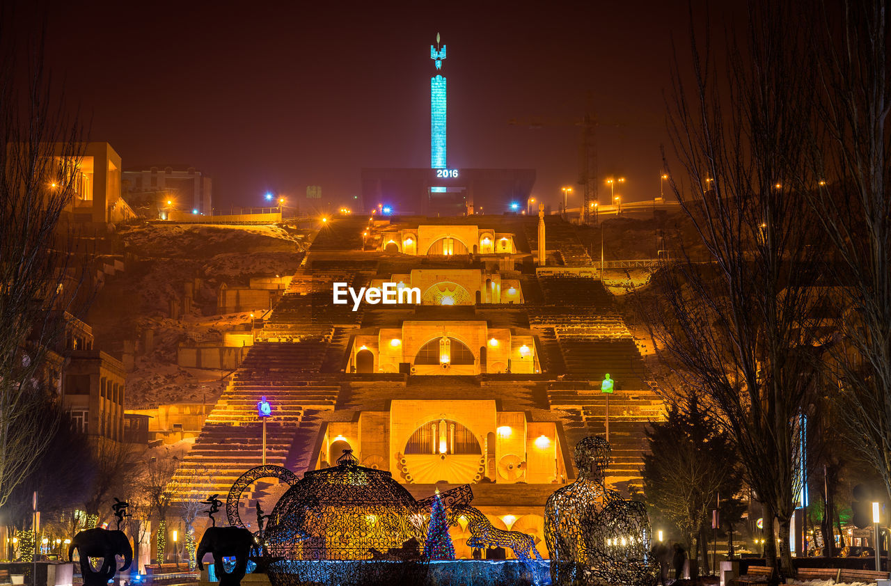 ILLUMINATED BUILDINGS AGAINST SKY AT NIGHT