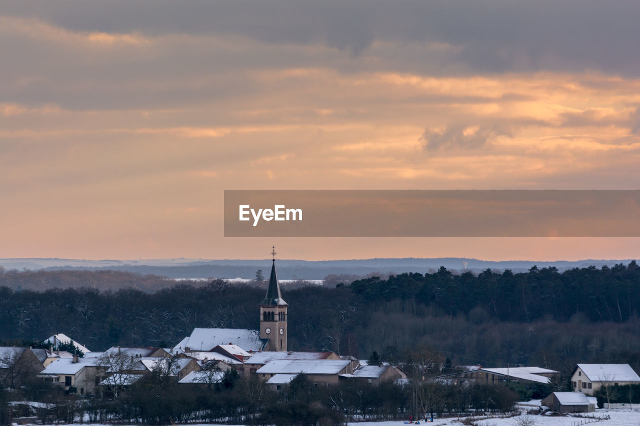 View of tower against cloudy sky during winter