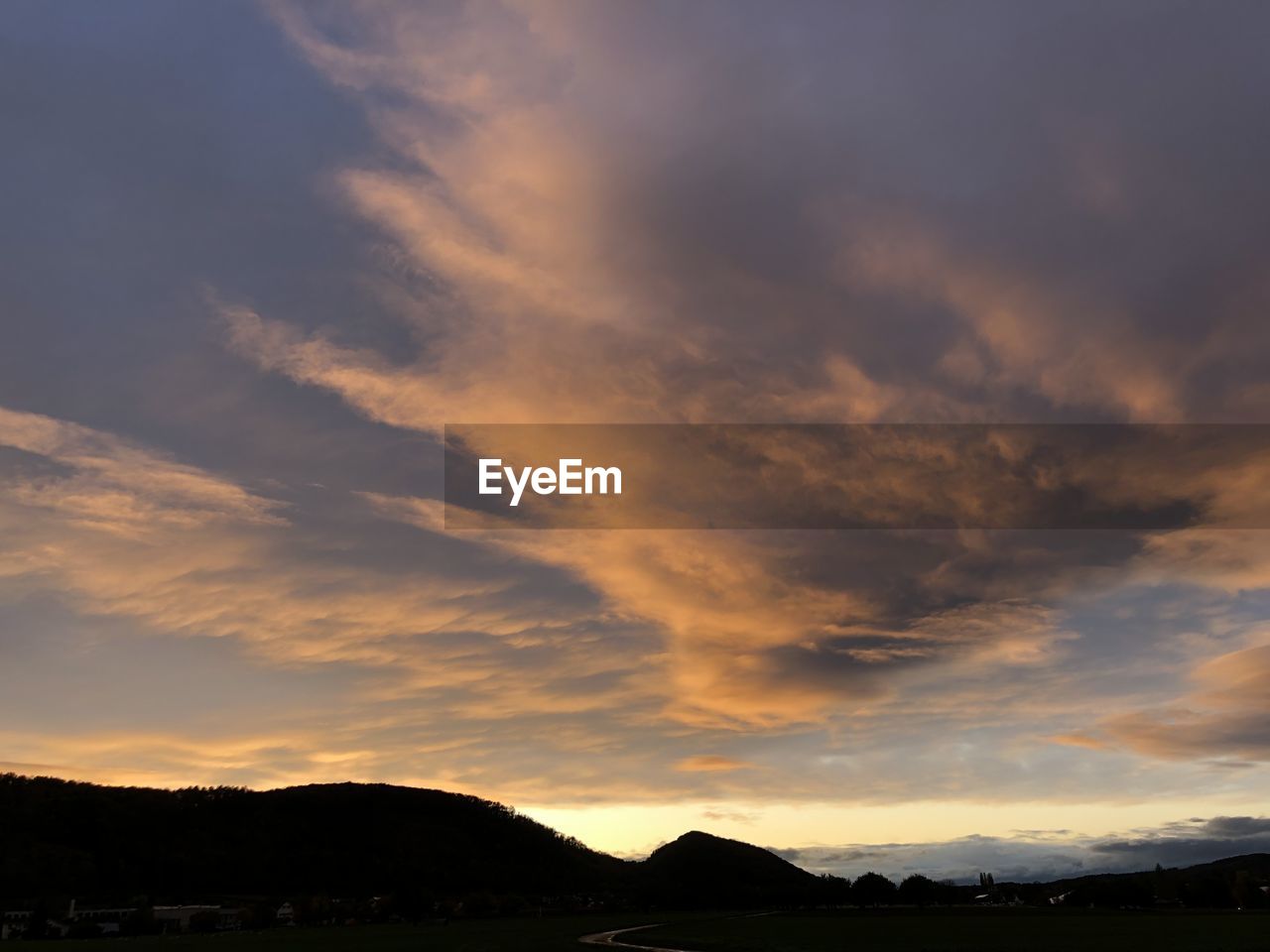 Low angle view of silhouette mountain against dramatic sky