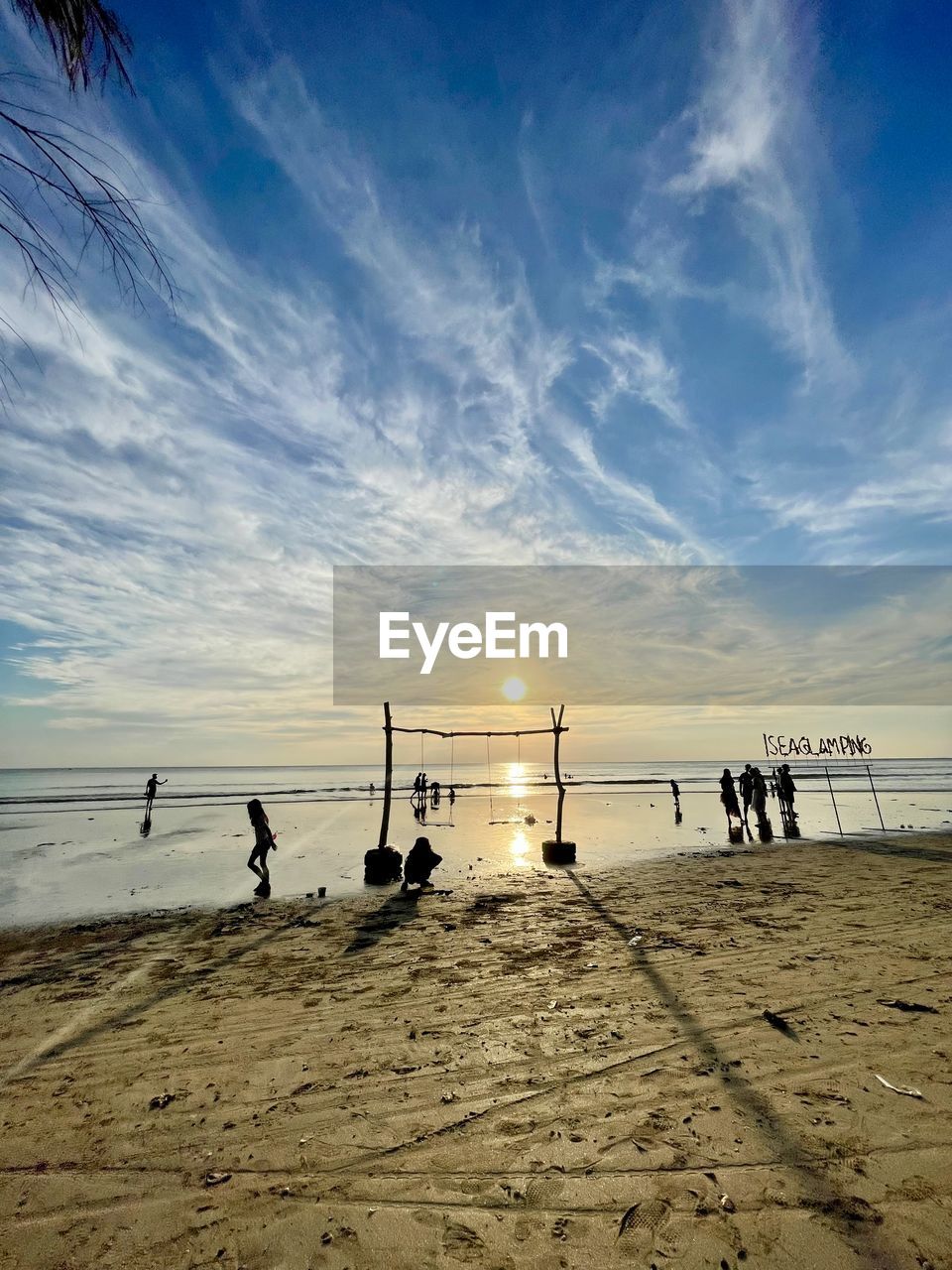 sky, beach, horizon, land, sea, water, shore, ocean, sand, body of water, nature, wave, cloud, group of people, coast, sunset, sunlight, beauty in nature, scenics - nature, horizon over water, dusk, holiday, silhouette, trip, vacation, sun, evening, tranquility, leisure activity, outdoors, men, tranquil scene, summer, medium group of people, blue, group, lifestyles, sports, travel, travel destinations, adult