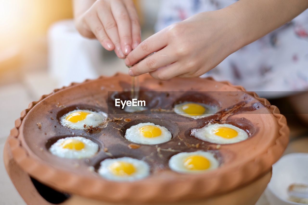 Child hand hammering quail eggs into the pan. quail egg mortar, thai food