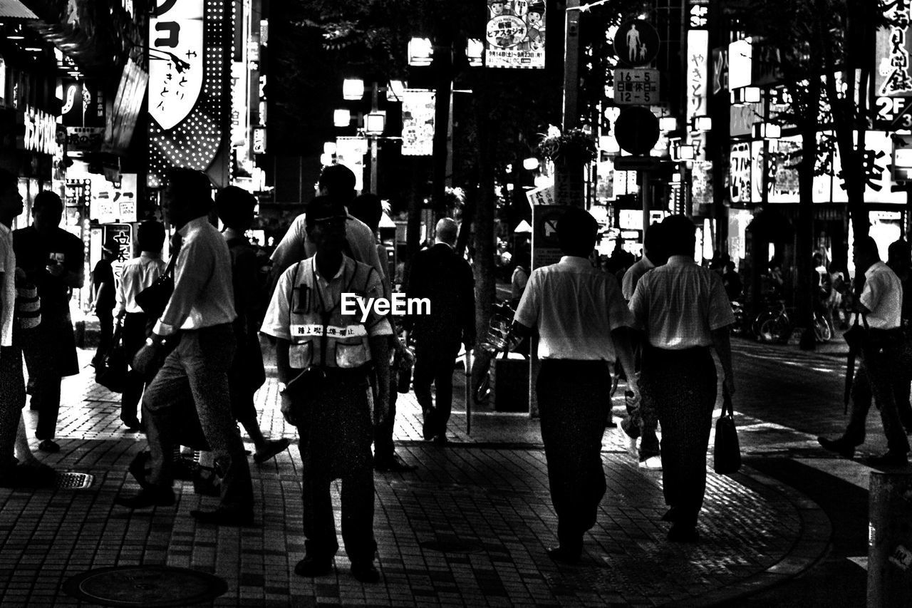 People walking on city street at night