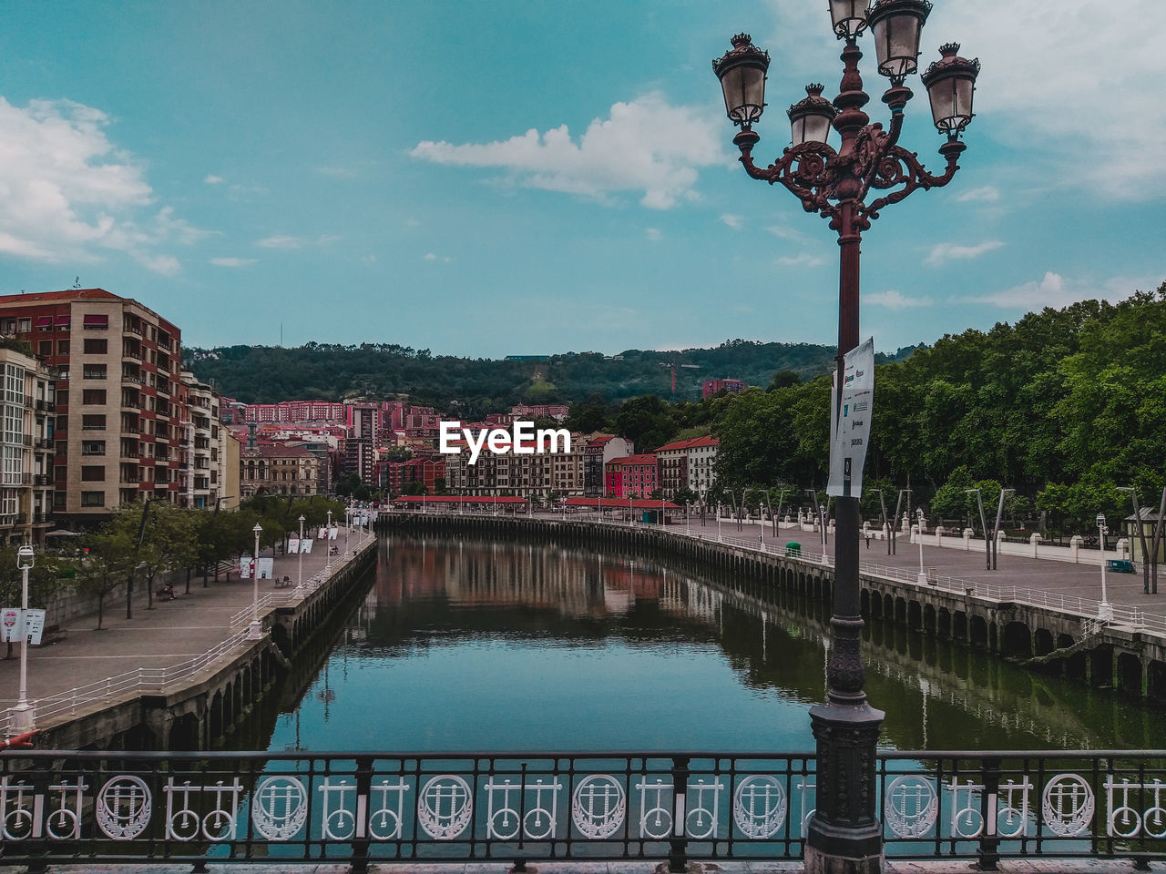 BRIDGE OVER RIVER BY CITY BUILDINGS AGAINST SKY