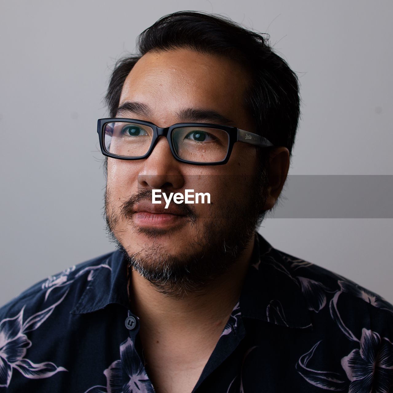 Portrait of young man wearing eyeglasses against white background