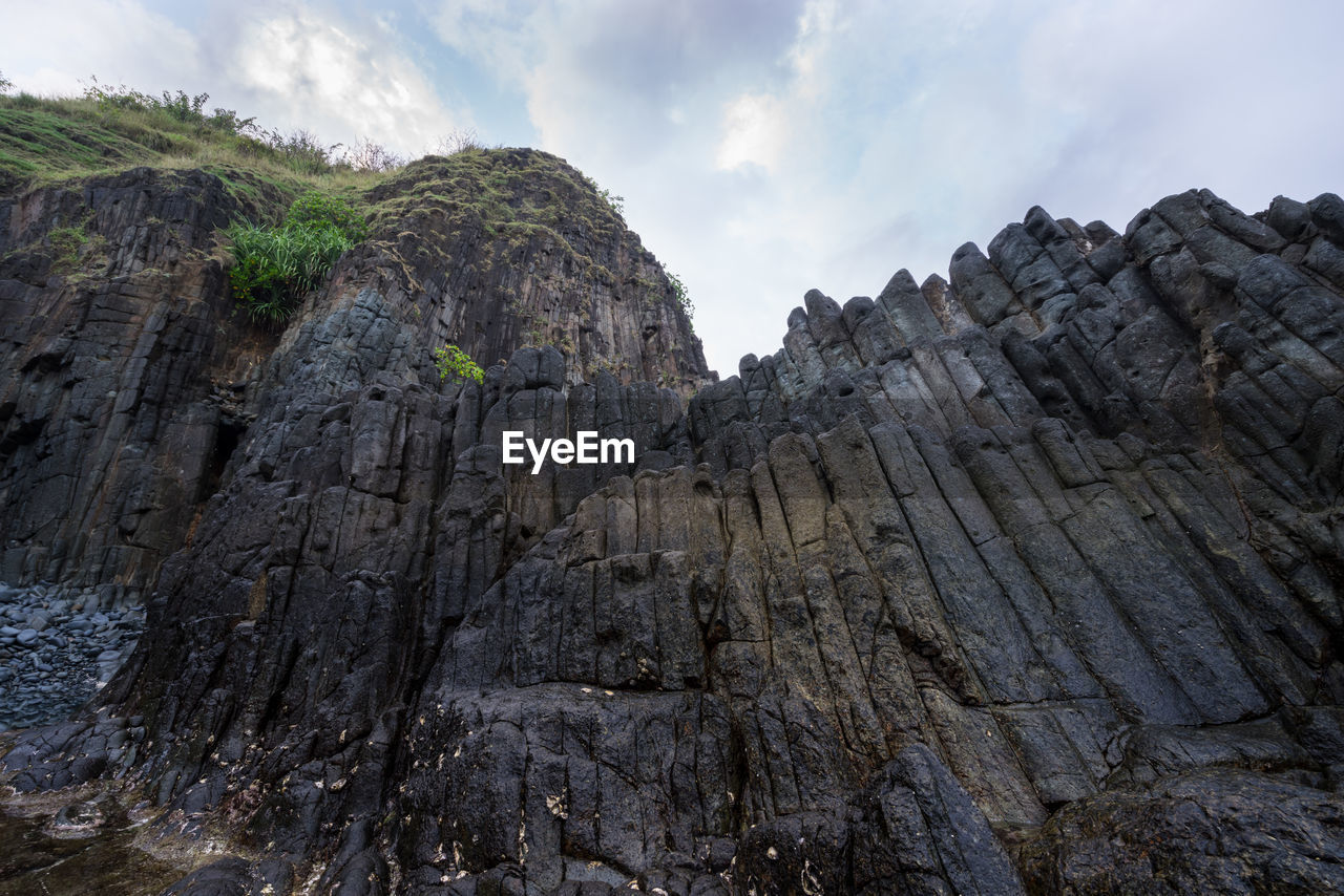 Low angle view of rocky mountains against sky at lombok