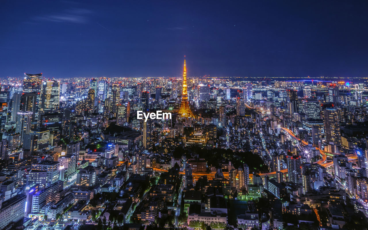 AERIAL VIEW OF ILLUMINATED CITY BUILDINGS AT NIGHT