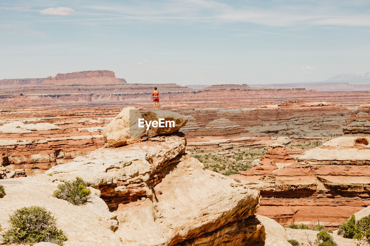 Woman hiker takes in the view on a ledge overlooking the maze utah