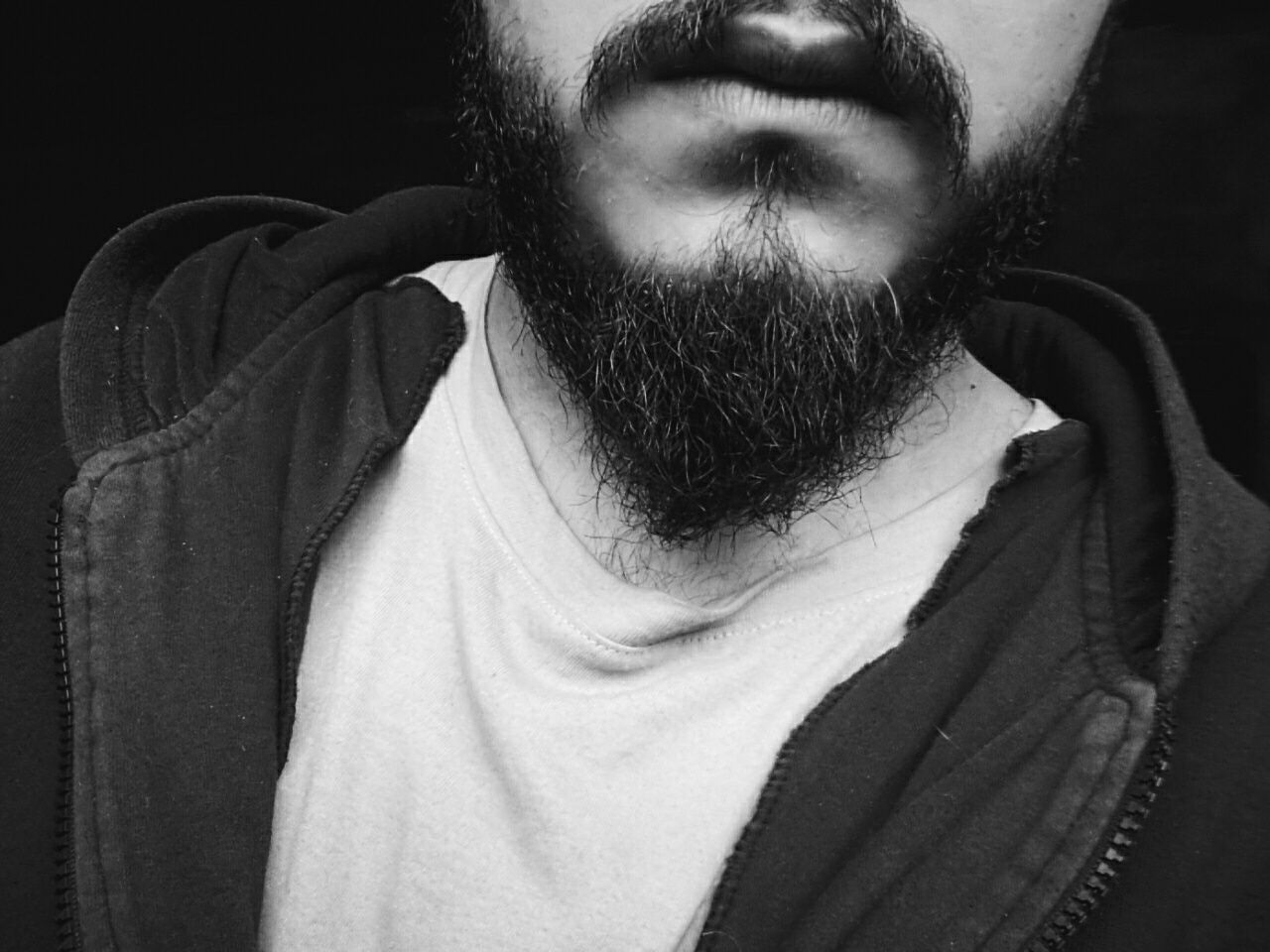 Midsection of bearded man against black background