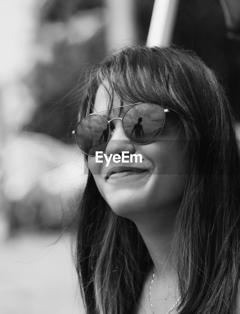 Close-up of smiling young woman wearing sunglasses